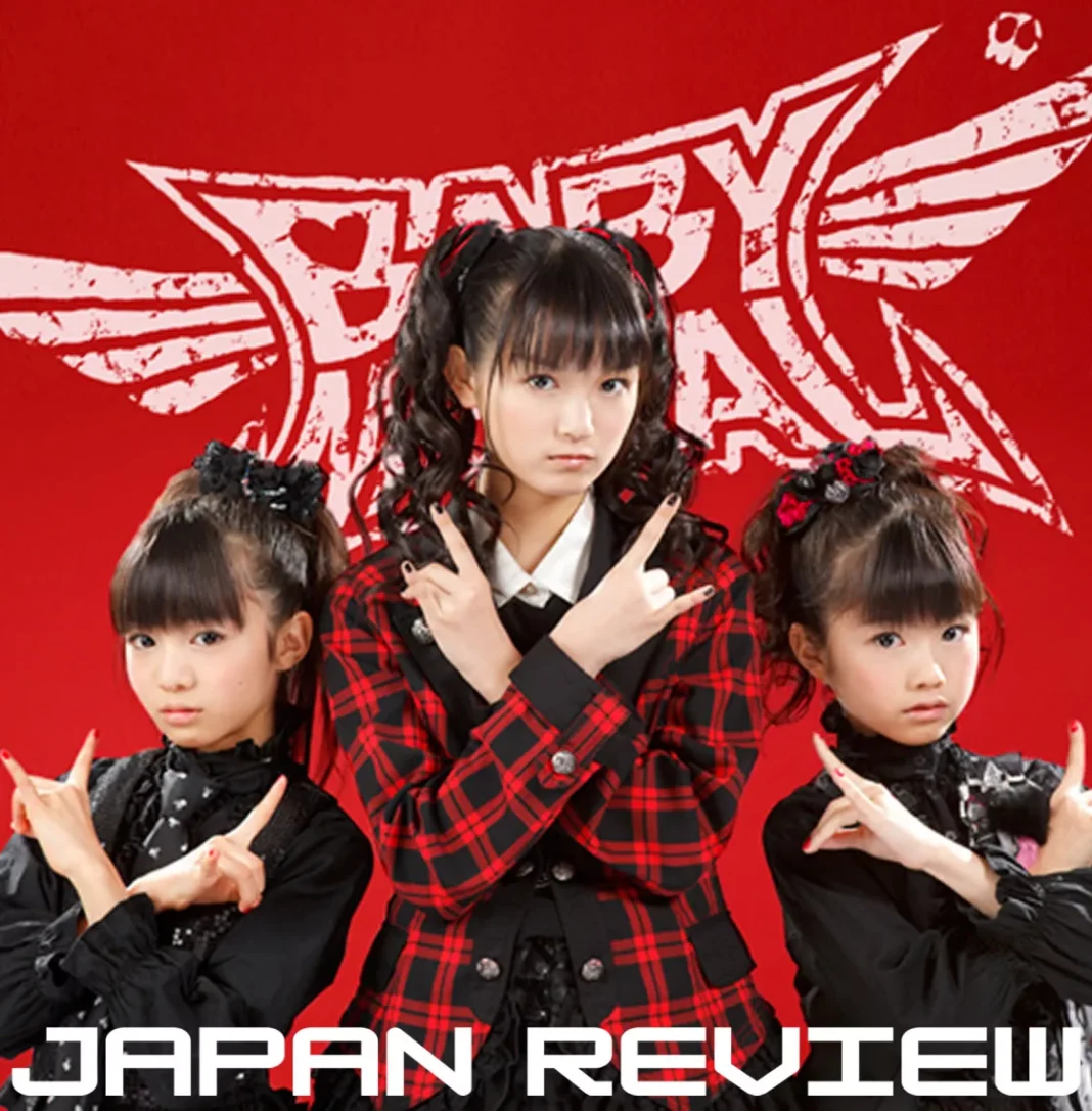 Integrantes da banda japonesa BABYMETAL durante show com iluminação intensa e performance de heavy metal.